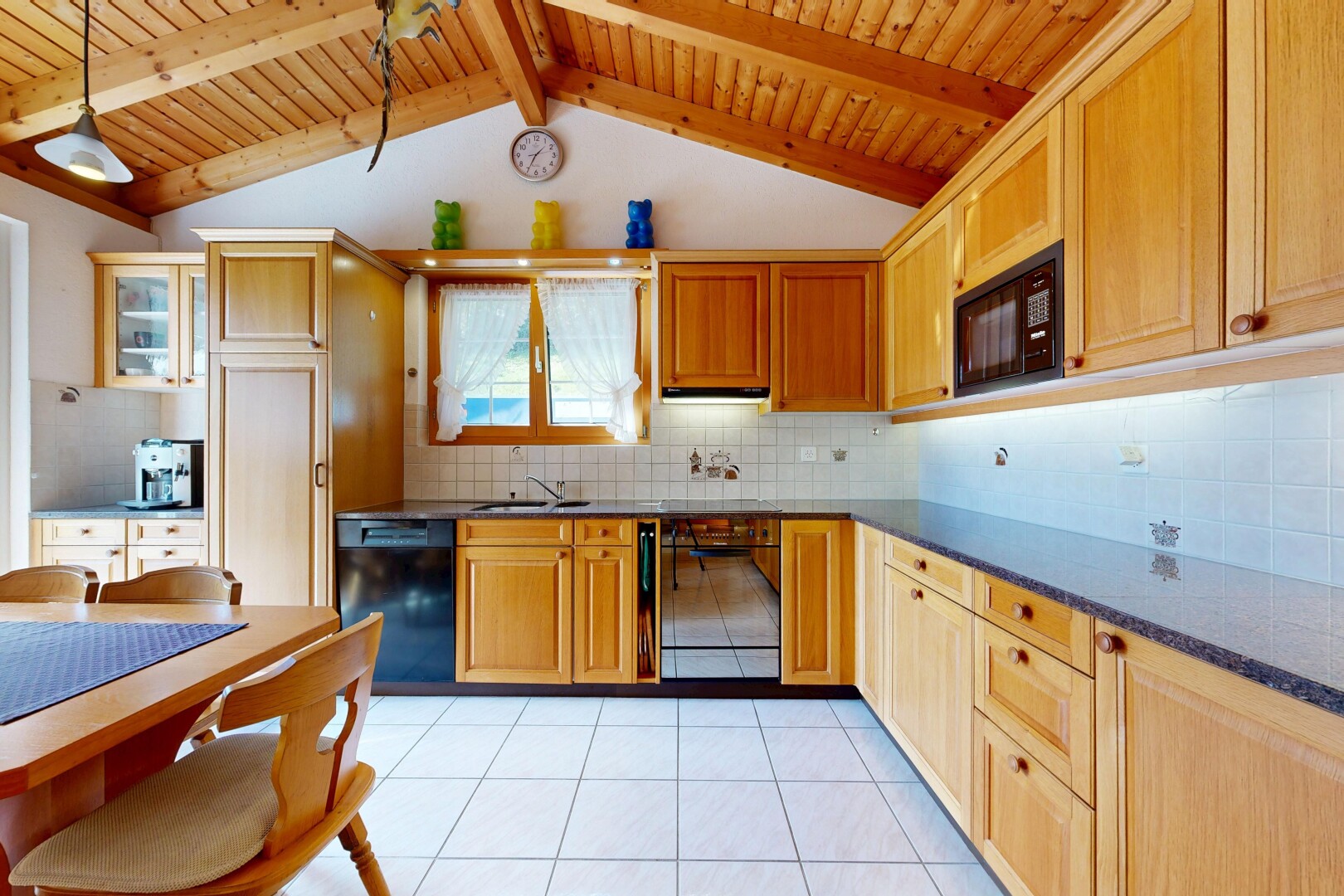 cuisine avec dark countertops, backsplash, dosseret, lave-vaisselle, et light floor