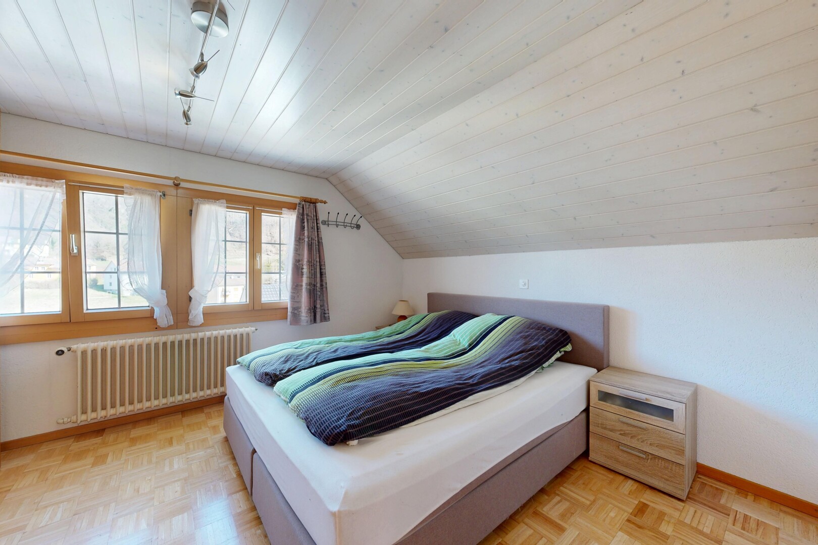 chambre avec radiateur, light floor, inside property, sol en finition bois, et wood finish floor