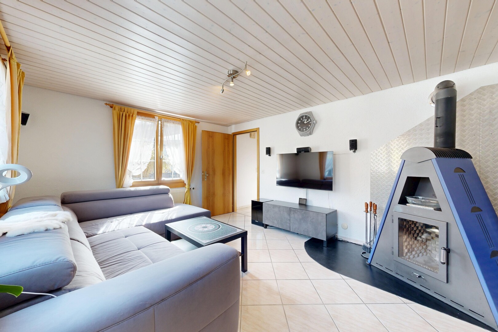 salon avec télévision, inside property, natural light, lumière naturelle, et wood ceiling