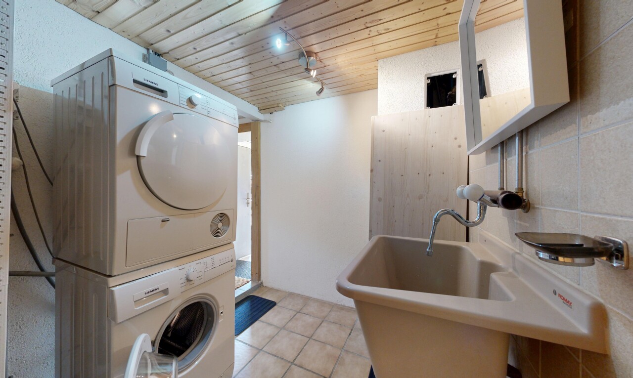 buanderie avec inside property, light floor, plafond en bois, wood ceiling, et lave-linge et sèche-linge superposés