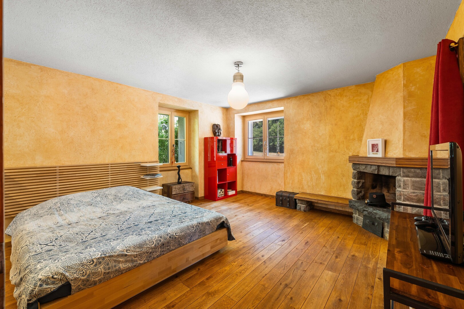 chambre avec télévision, inside property, sol en finition bois, wood finish floor, et lumière naturelle