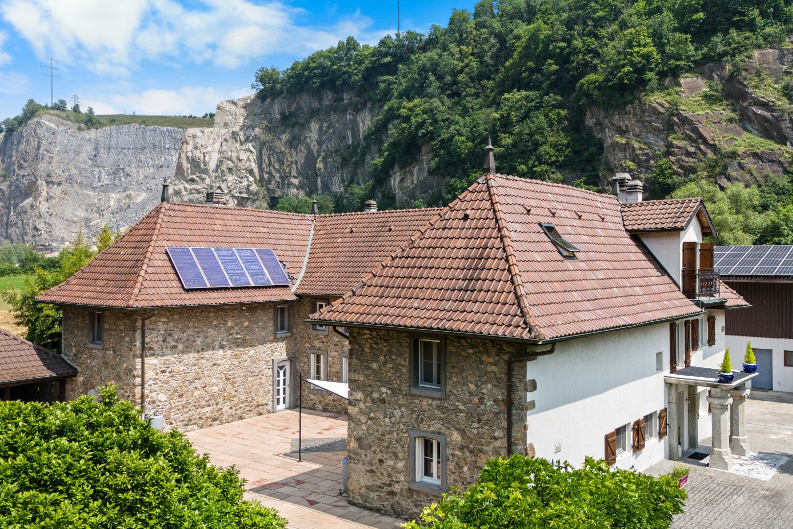 façade avec property visible, panneaux solaires, cheminée, day time, et toit en tuiles