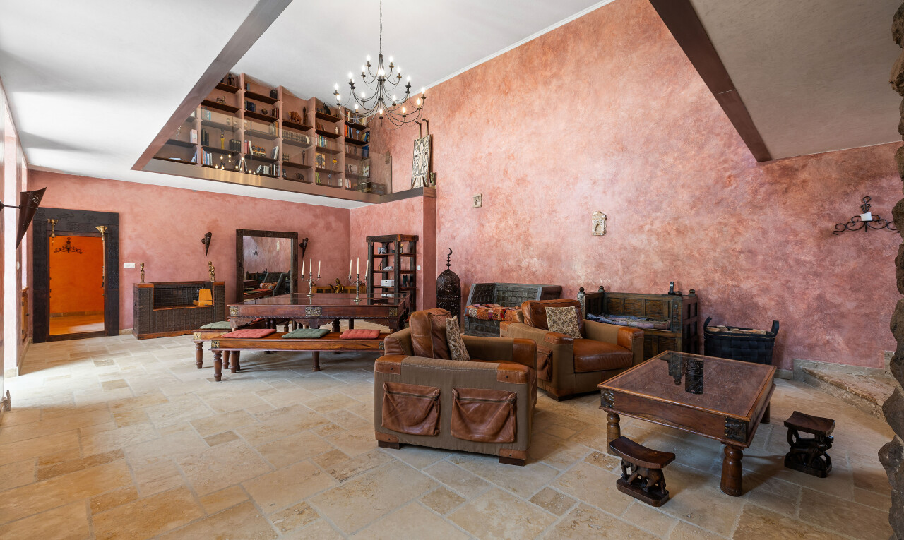salon avec stone finish floor, sol en finition pierre, inside property, lustre remarquable, et high ceiling