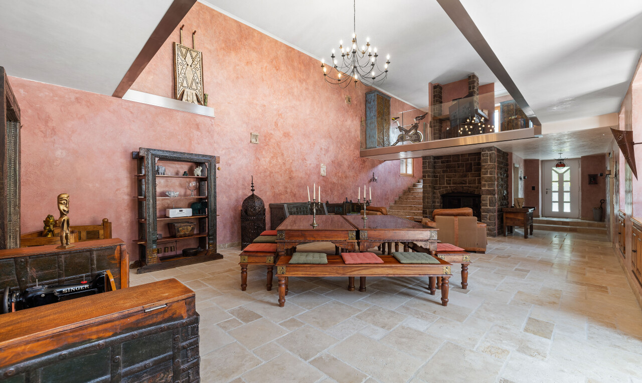 salon avec sol en finition pierre, stone finish floor, cheminée, lumière naturelle, et natural light