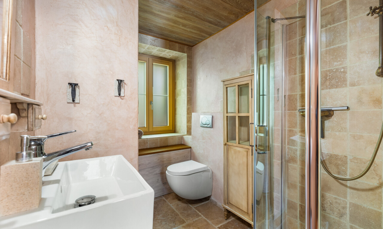 salle de bains avec toilette, inside property, douche, plafond en bois, et wood ceiling