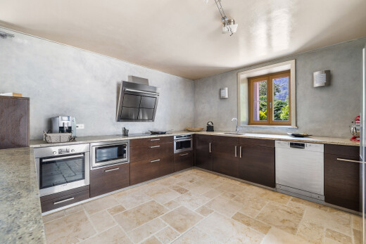 cuisine avec four, lave-vaisselle, micro-ondes, plans de travail, et stone finish floor