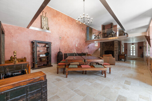 salon avec sol en finition pierre, stone finish floor, cheminée, lumière naturelle, et natural light
