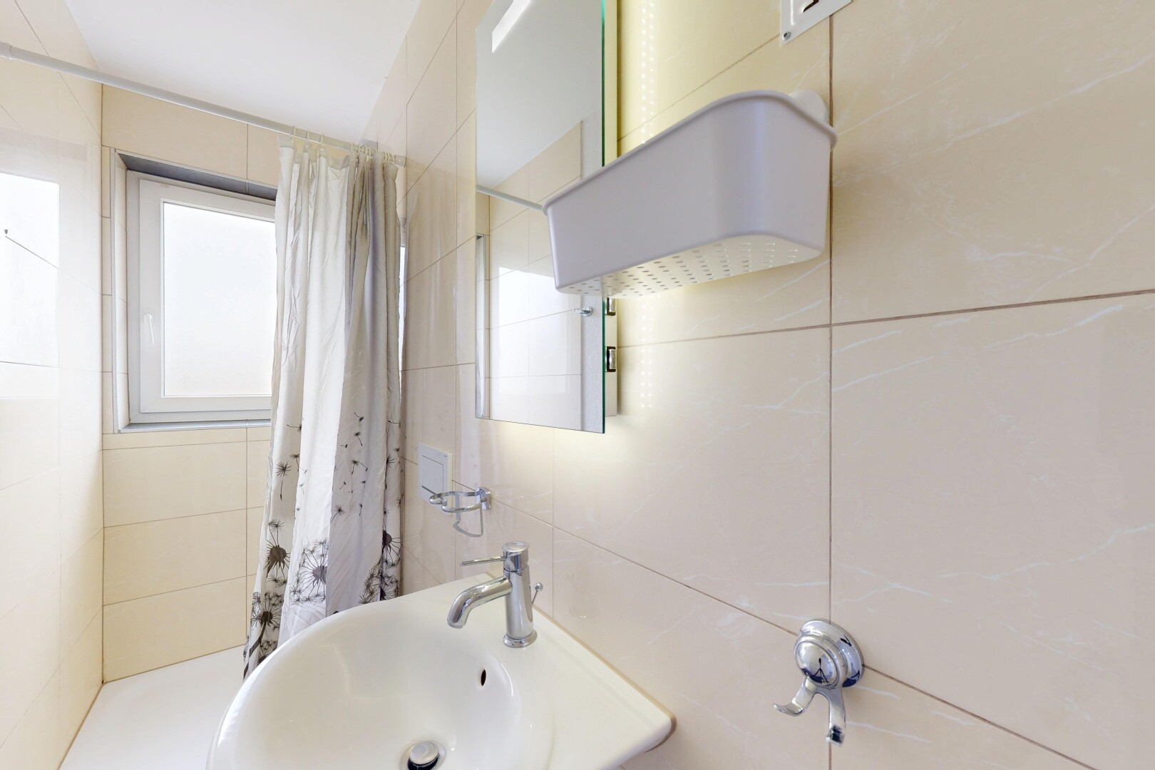 salle de bains avec natural light, lumière naturelle, évier, inside property, et tile wall