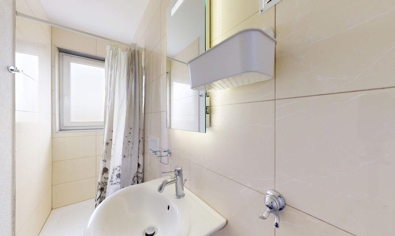 salle de bains avec natural light, lumière naturelle, évier, inside property, et tile wall