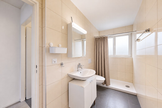 bathroom featuring a shower stall, tile walls, and dark tile patterned floors