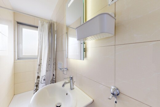 salle de bains avec natural light, lumière naturelle, évier, inside property, et tile wall