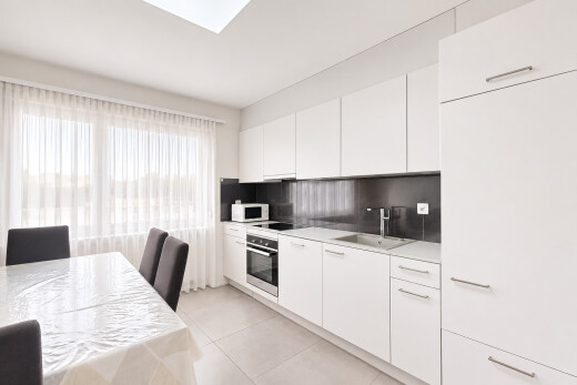 kitchen featuring white cabinets, light countertops, stainless steel oven, and modern cabinets