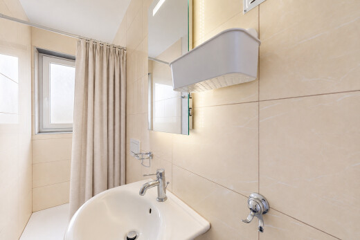 bathroom with a shower with shower curtain and tile walls