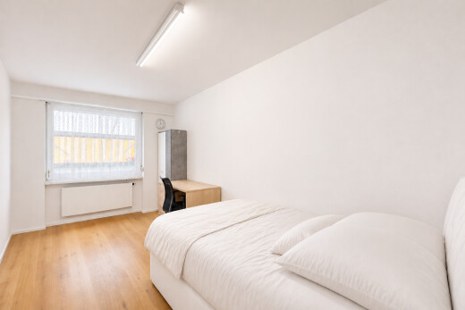 chambre avec lumière naturelle, cloison sèche, drywall, espace bureau, et sol en finition bois