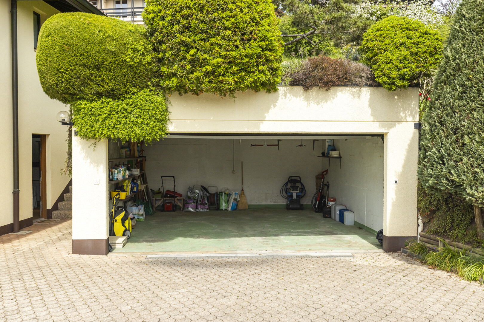 façade avec garage, bardage en stuc, property visible, et terrasse