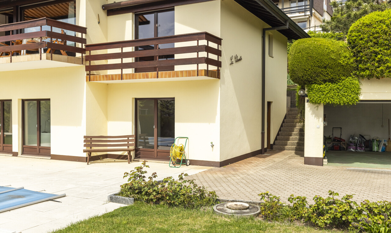 façade avec balcon, terrasse, escaliers, bardage en stuc, et property visible