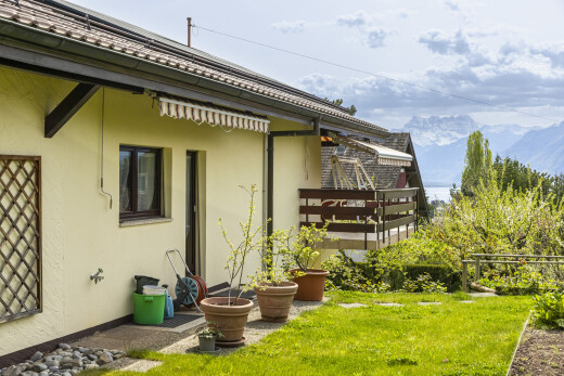 façade avec bardage en stuc, auvent, from property, pelouse, et vue sur la montagne