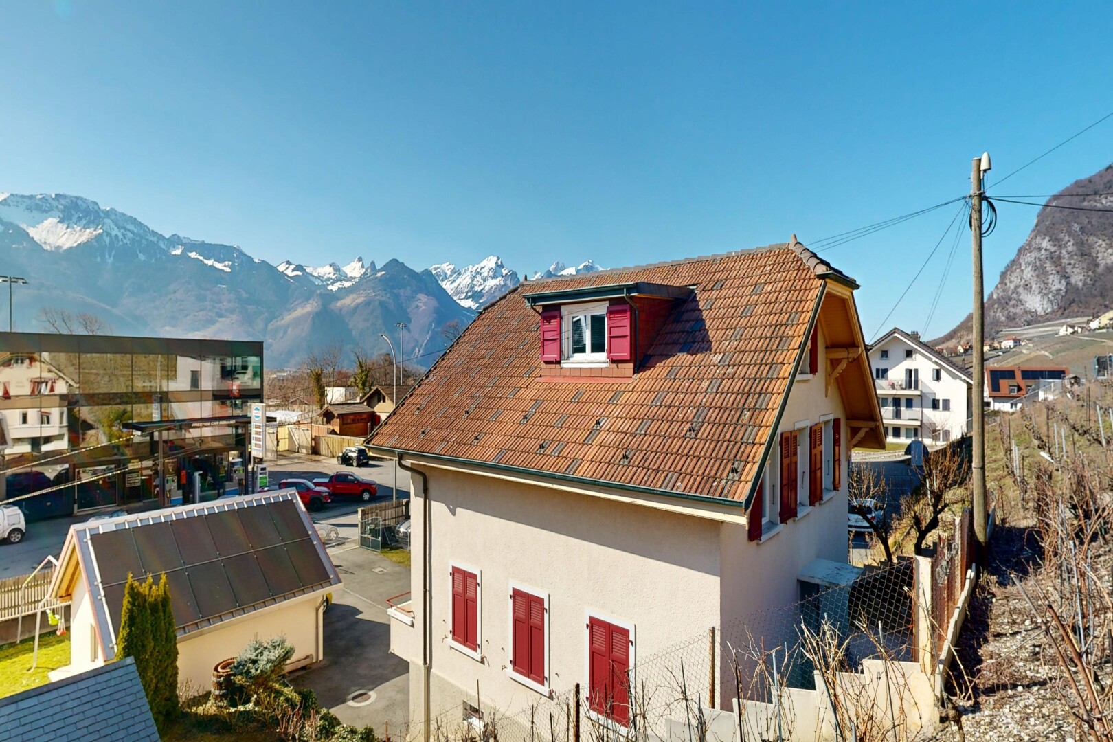 façade avec vue sur la montagne, mountain view, bardage en stuc, day time, et toit mansardé