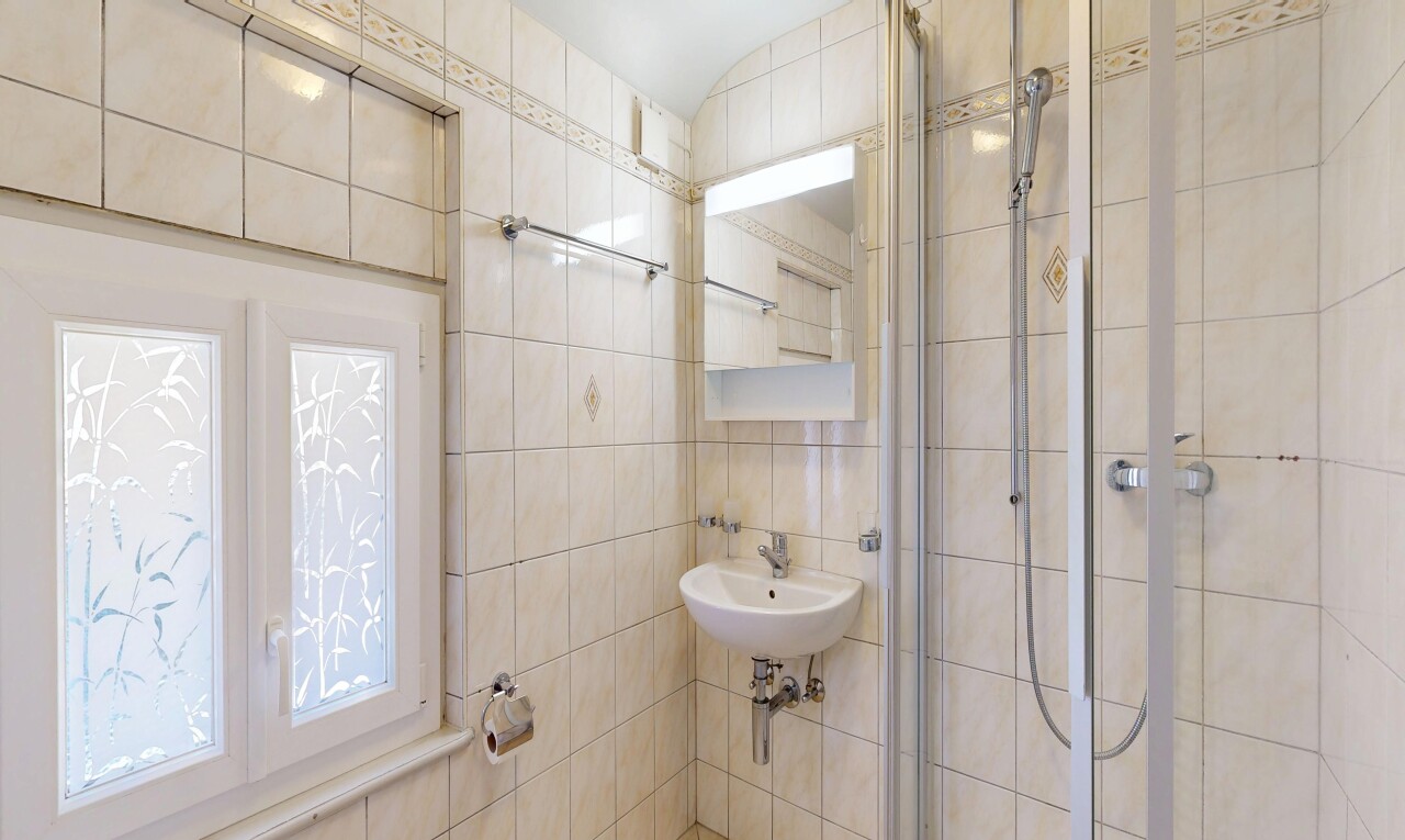 salle de bains avec tile wall, mur en carrelage, miroir, douche, et salle de bain complète