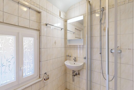 salle de bains avec tile wall, mur en carrelage, miroir, douche, et salle de bain complète