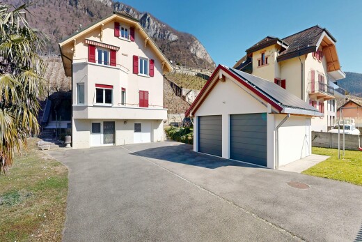 façade avec mountain view, vue sur la montagne, bardage en stuc, structure extérieure, et garage détaché
