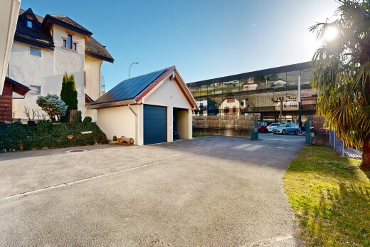 façade avec structure extérieure, garage détaché, day time, toit en métal, et bardage en stuc