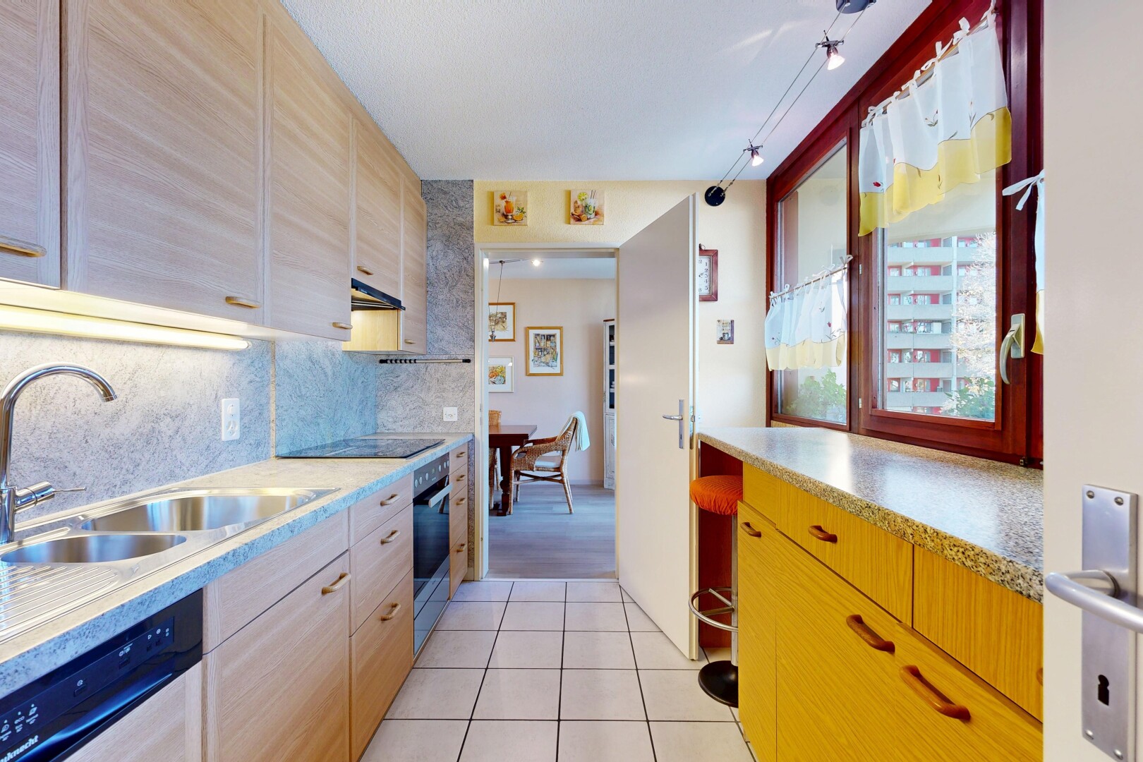 kitchen featuring light tile patterned flooring, backsplash, dishwasher, oven, and light brown cabinets