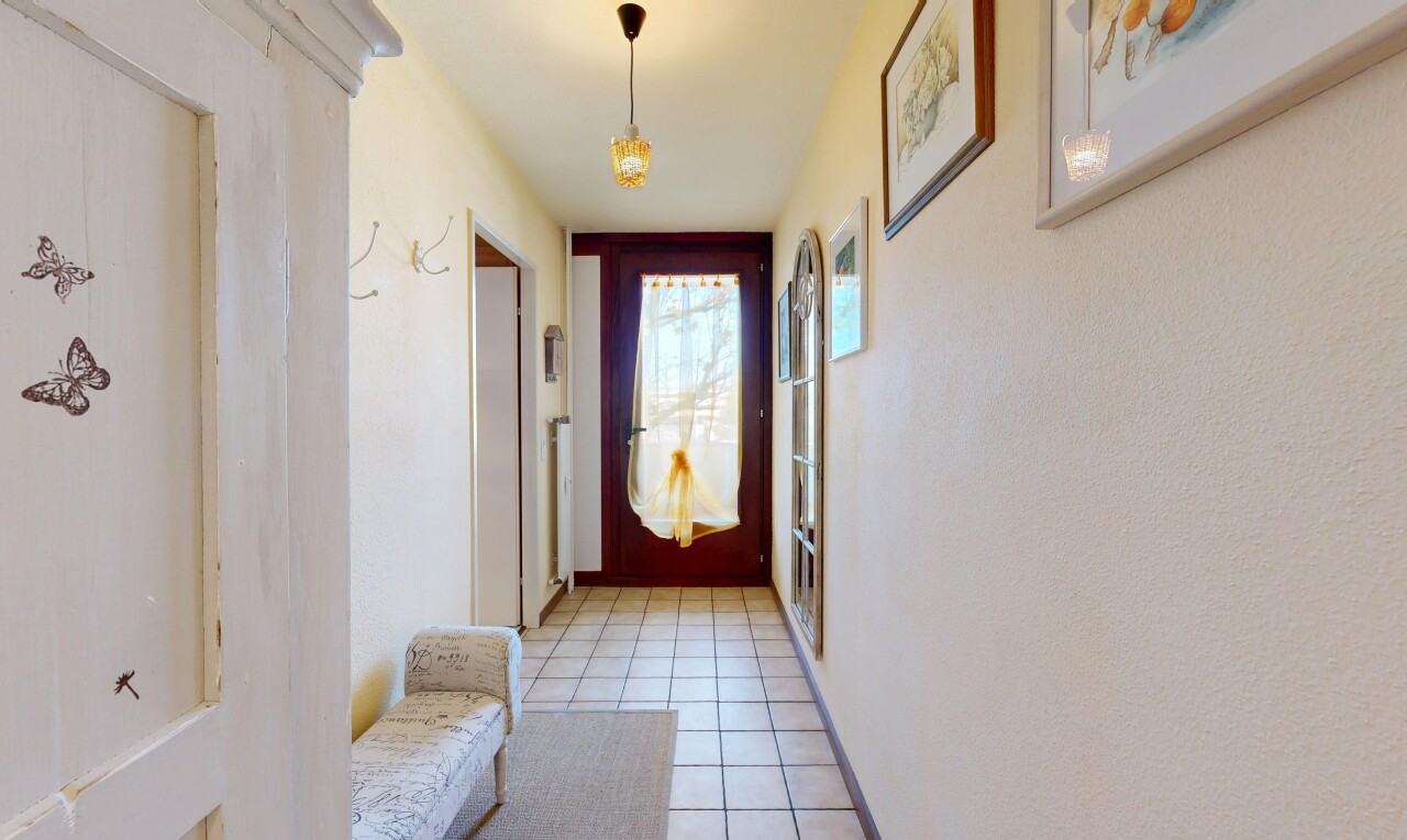 hallway featuring light tile patterned flooring and baseboards