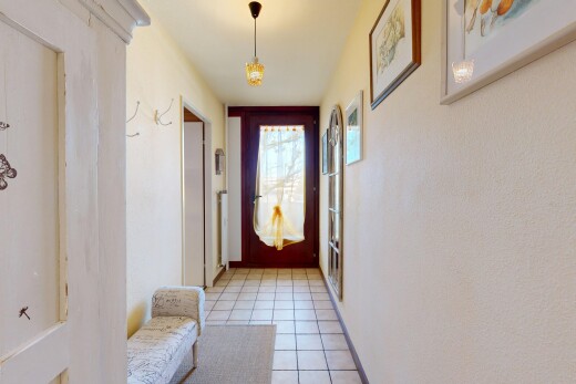 hallway featuring light tile patterned flooring and baseboards