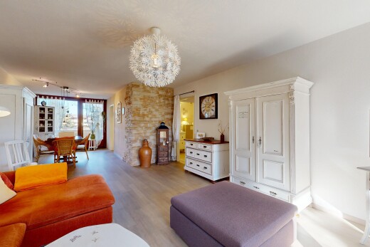 wohn- / esszimmer mit bemerkenswerter kronleuchter, inside property, wood finish floor, holzfußboden, und drywall