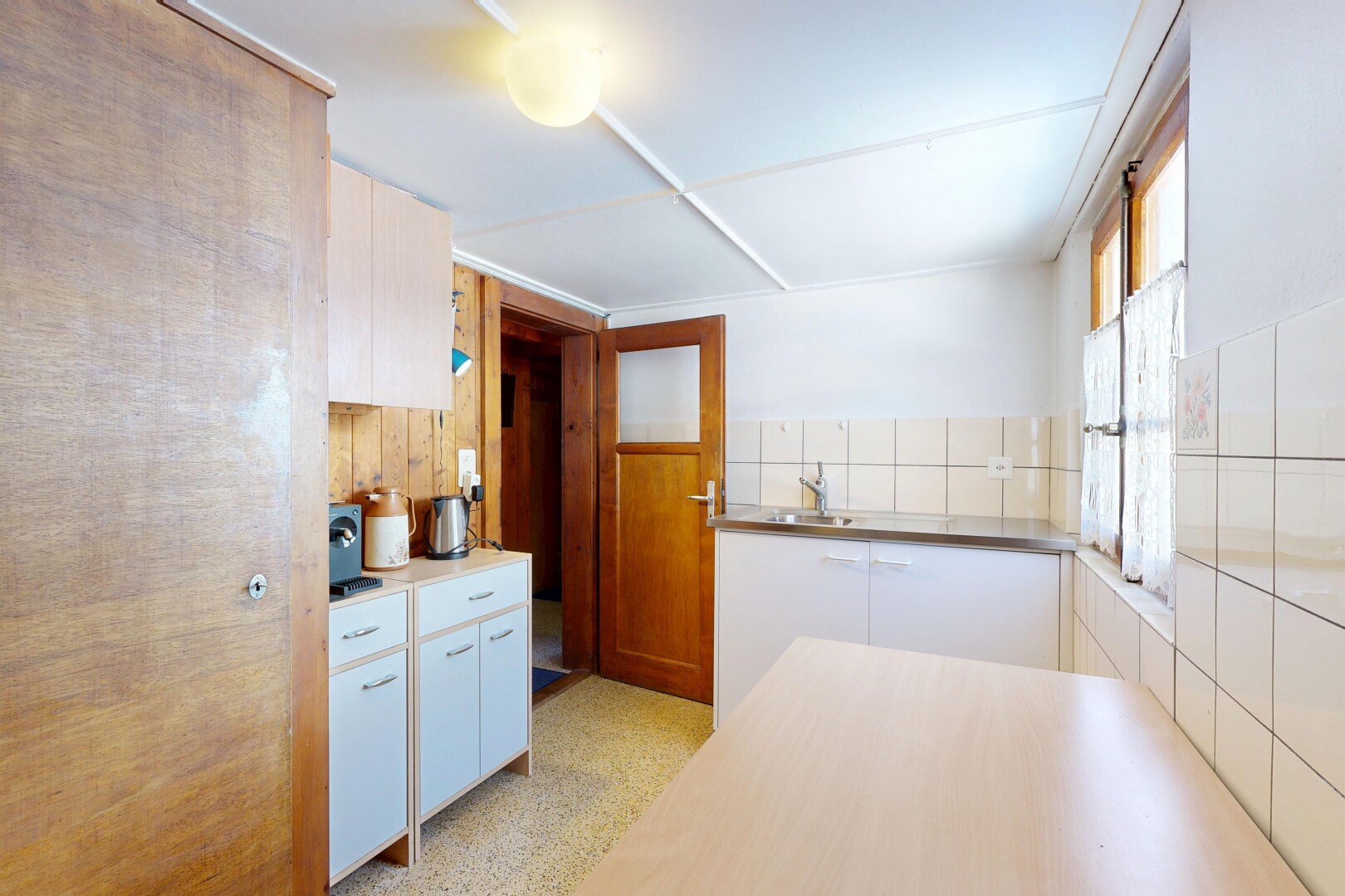 cuisine avec armoires blanches, white cabinets, light floor, inside property, et natural light