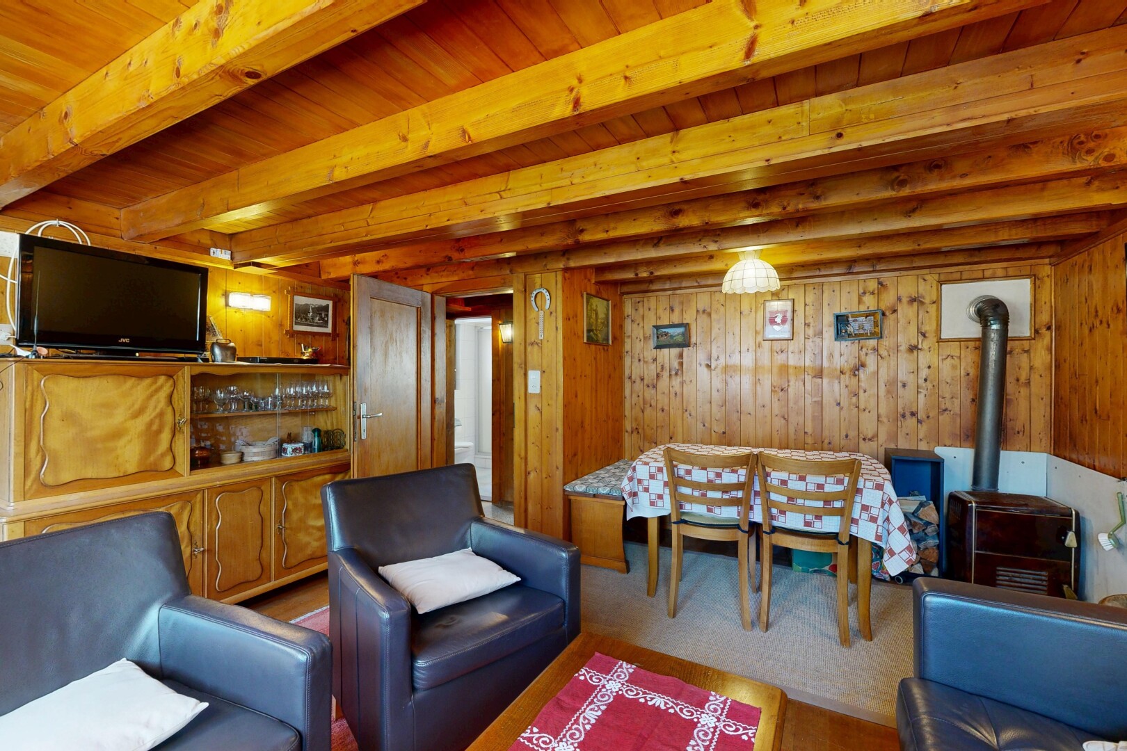 salon / salle à manger avec inside property, télévision, wood wall, mur en bois, et poêle à bois