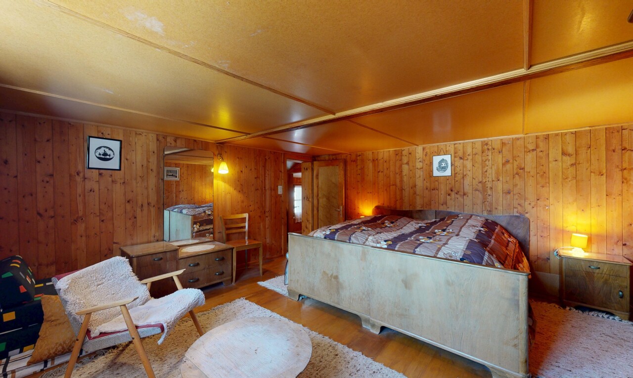 chambre avec wood finish floor, sol en finition bois, inside property, wood wall, et mur en bois