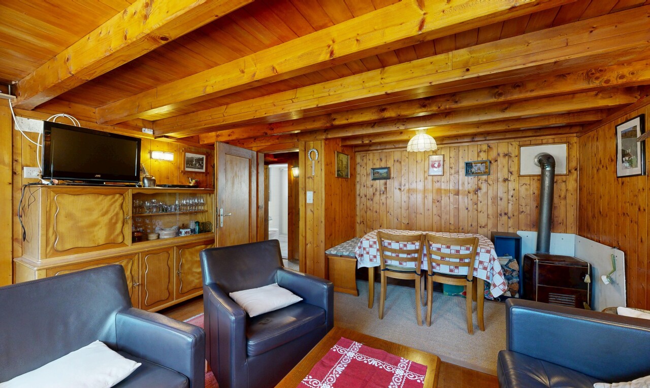 salon / salle à manger avec inside property, télévision, wood wall, mur en bois, et poêle à bois