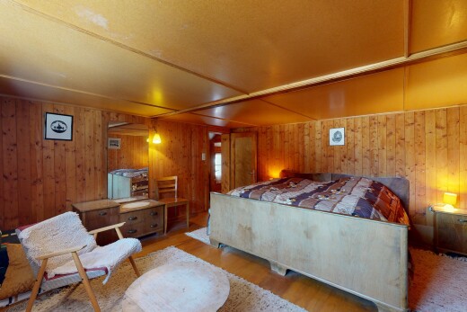 chambre avec wood finish floor, sol en finition bois, inside property, wood wall, et mur en bois