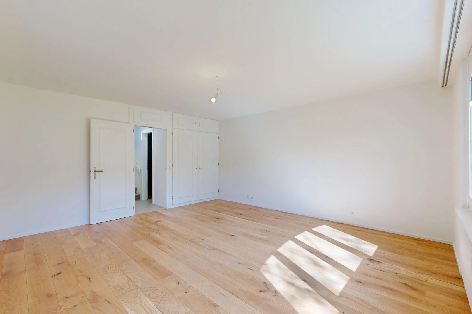 pièce vide avec drywall, cloison sèche, wood finish floor, sol en finition bois, et light floor