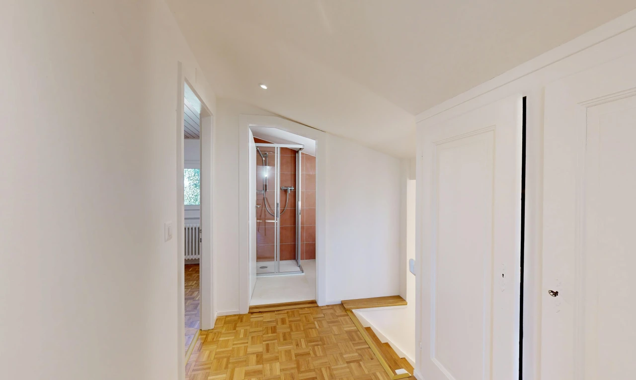 couloir avec sol en finition bois, wood finish floor, cloison sèche, drywall, et light floor