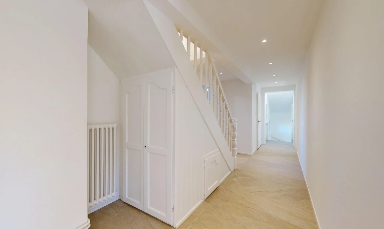 couloir avec radiateur, drywall, cloison sèche, éclairage encastré, et light floor