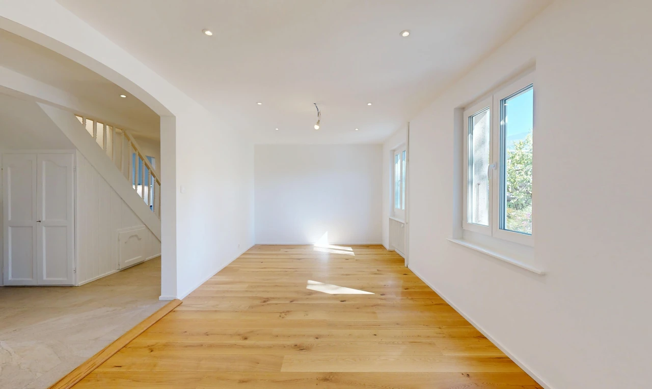 pièce vide avec escaliers, cloison sèche, drywall, passages en arc, et sol en finition bois