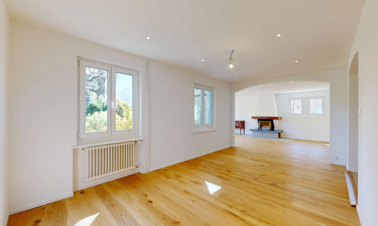 pièce vide avec wood finish floor, sol en finition bois, drywall, cloison sèche, et cheminée