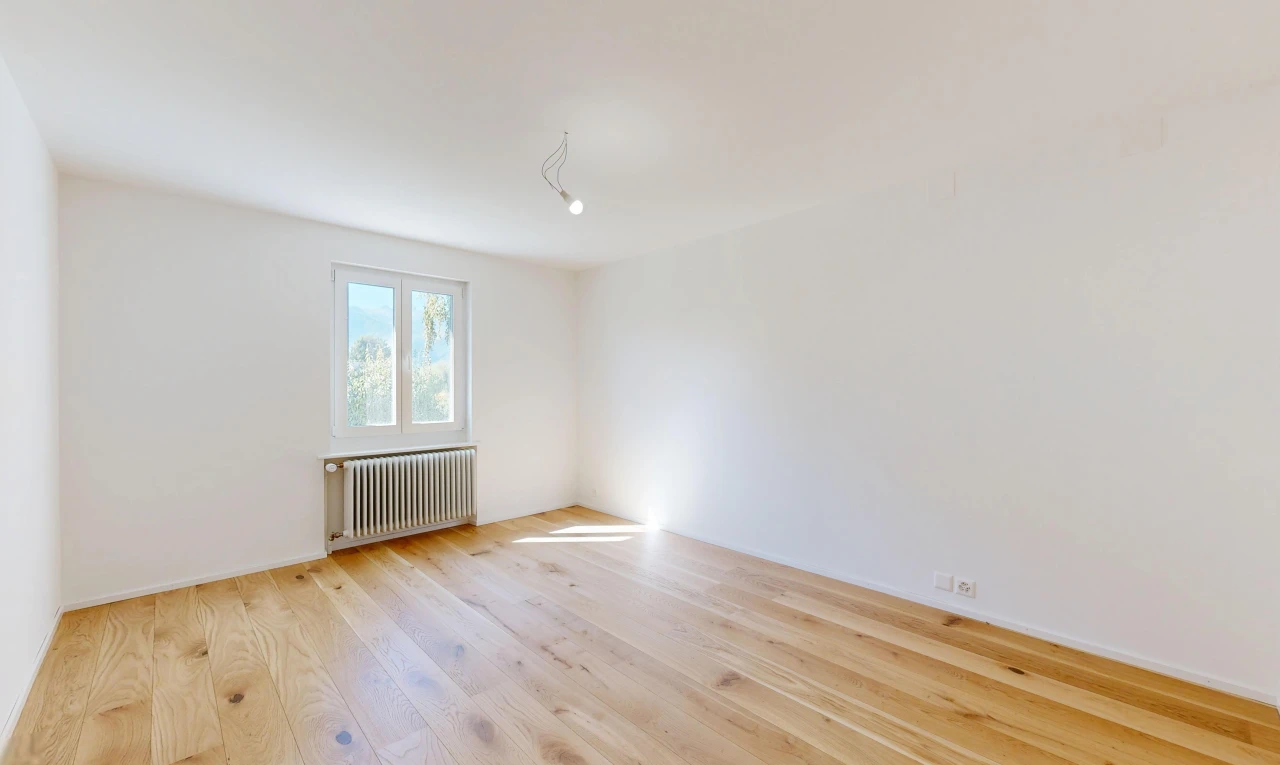pièce vide avec radiateur, cloison sèche, drywall, sol en finition bois, et wood finish floor