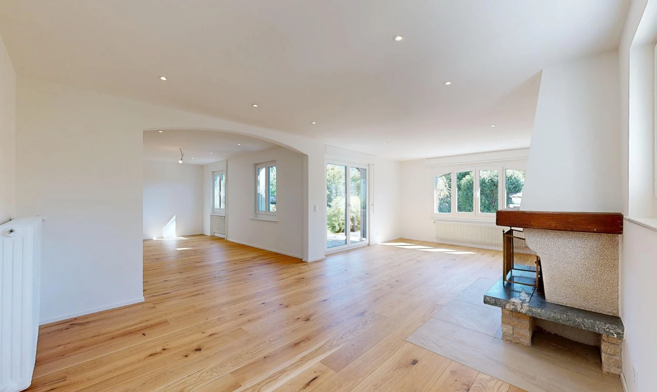 pièce vide avec passages en arc, wood finish floor, sol en finition bois, accès à l'extérieur, et drywall