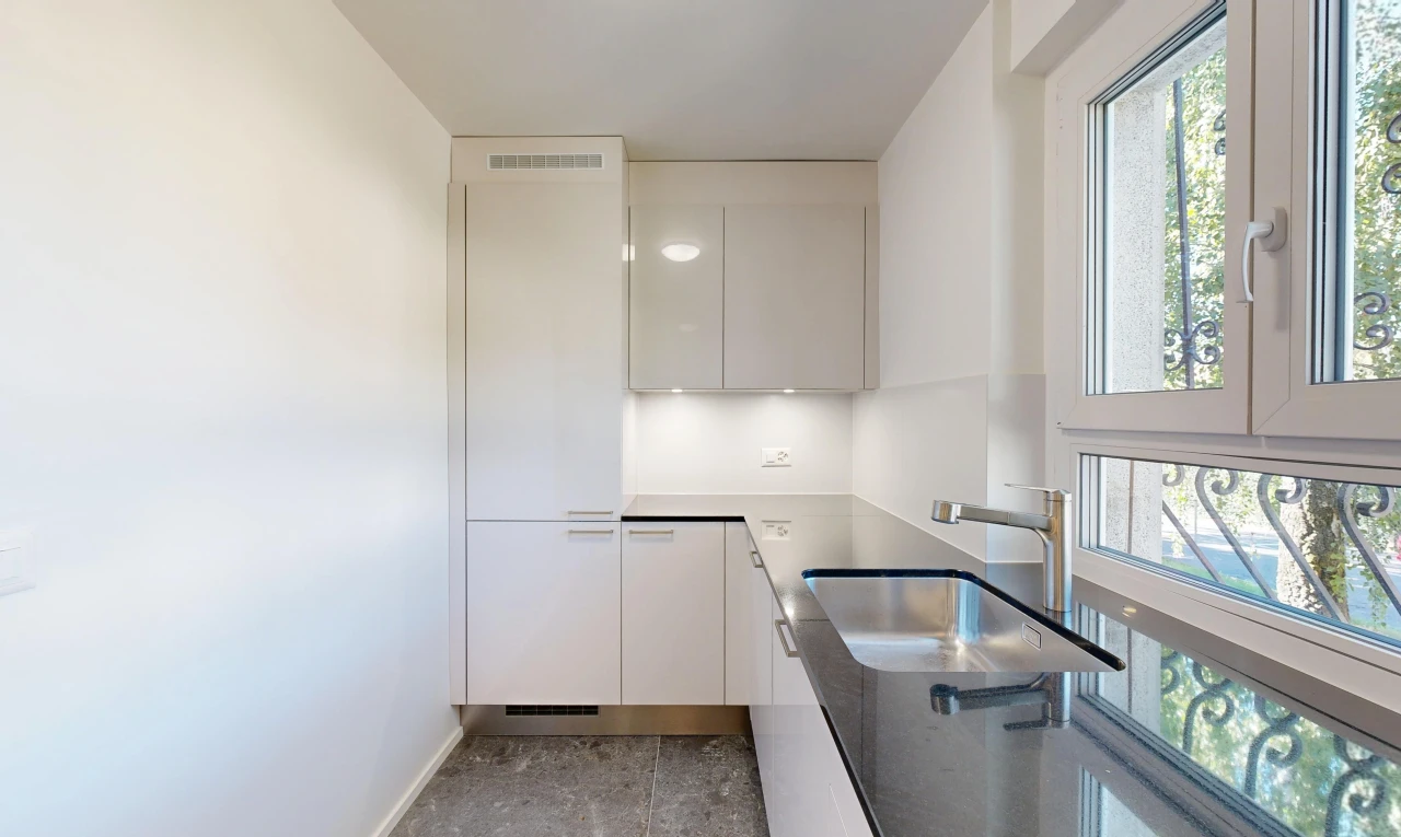 cuisine avec évier, cloison sèche, drywall, inside property, et armoires à panneau plat