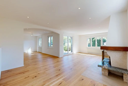pièce vide avec passages en arc, wood finish floor, sol en finition bois, accès à l'extérieur, et drywall