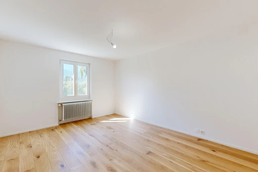 pièce vide avec radiateur, cloison sèche, drywall, sol en finition bois, et wood finish floor