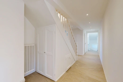 couloir avec radiateur, drywall, cloison sèche, éclairage encastré, et light floor