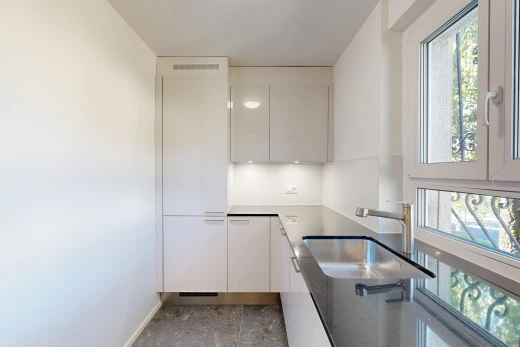 cuisine avec évier, cloison sèche, drywall, inside property, et armoires à panneau plat
