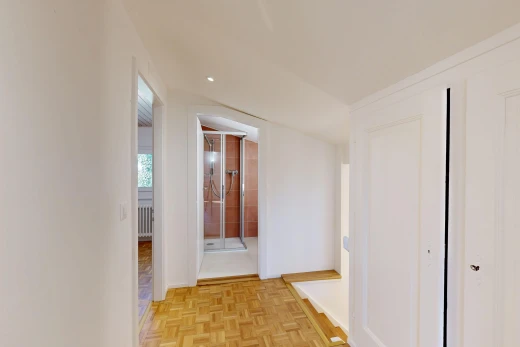couloir avec sol en finition bois, wood finish floor, cloison sèche, drywall, et light floor