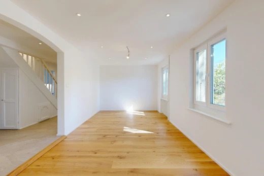 pièce vide avec escaliers, cloison sèche, drywall, passages en arc, et sol en finition bois