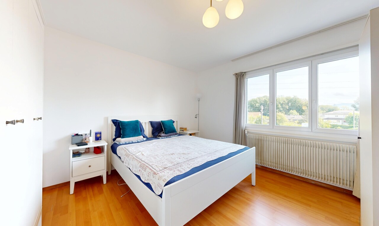 chambre avec radiateur, lumière naturelle, natural light, sol en finition bois, et wood finish floor